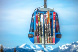 selective focus photography of ski blades on blue cable car