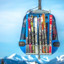selective focus photography of ski blades on blue cable car